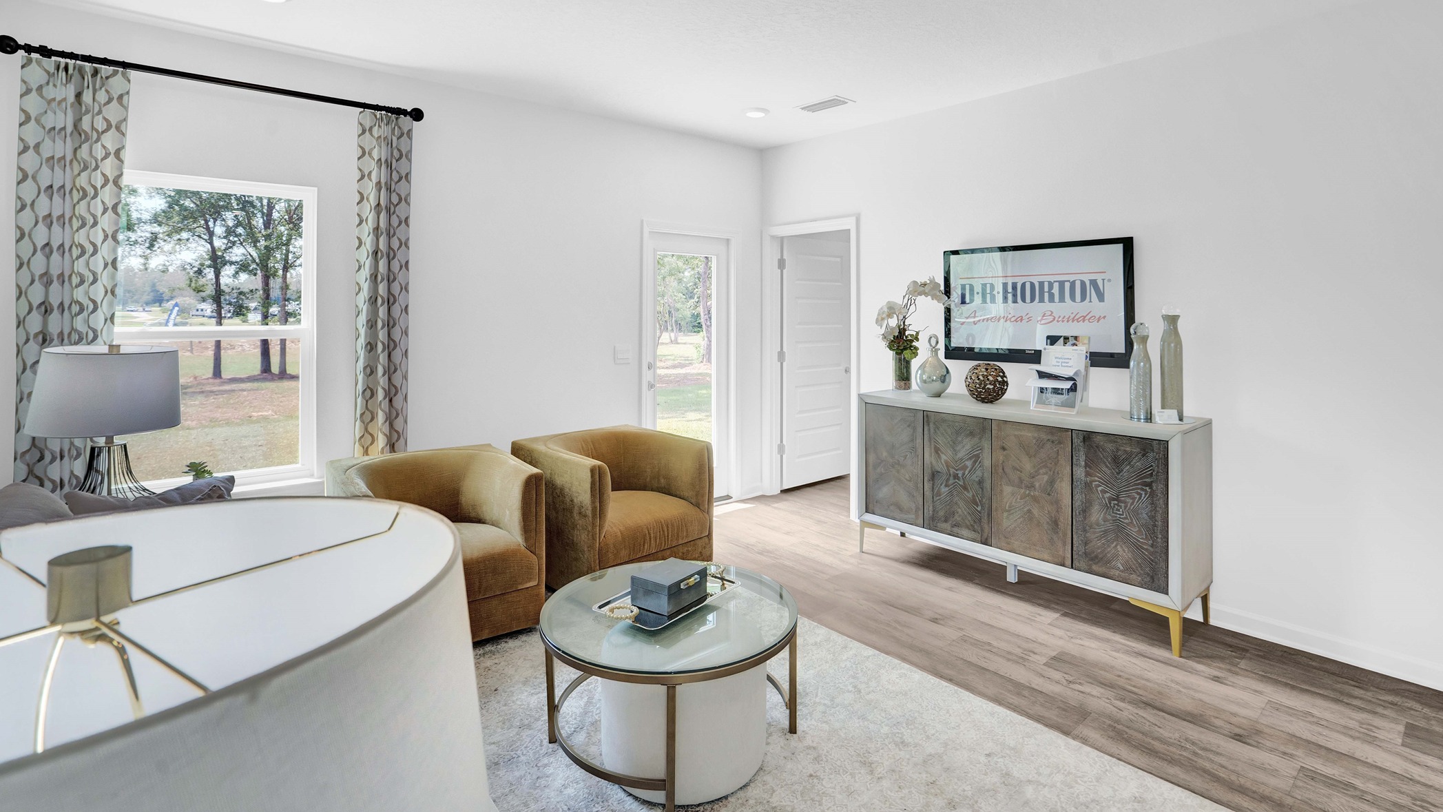 Living area with small table and furniture with television on top.