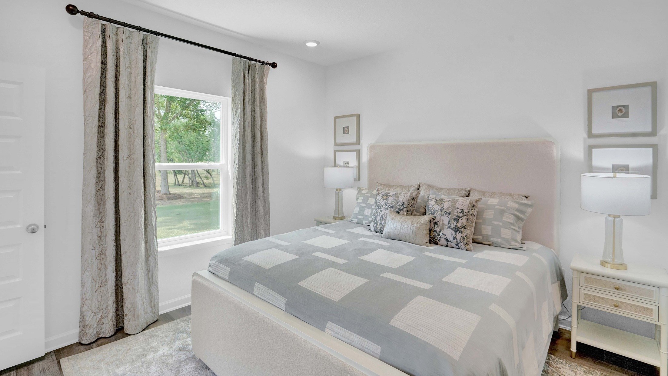 The primary bedroom has curtains and windows.