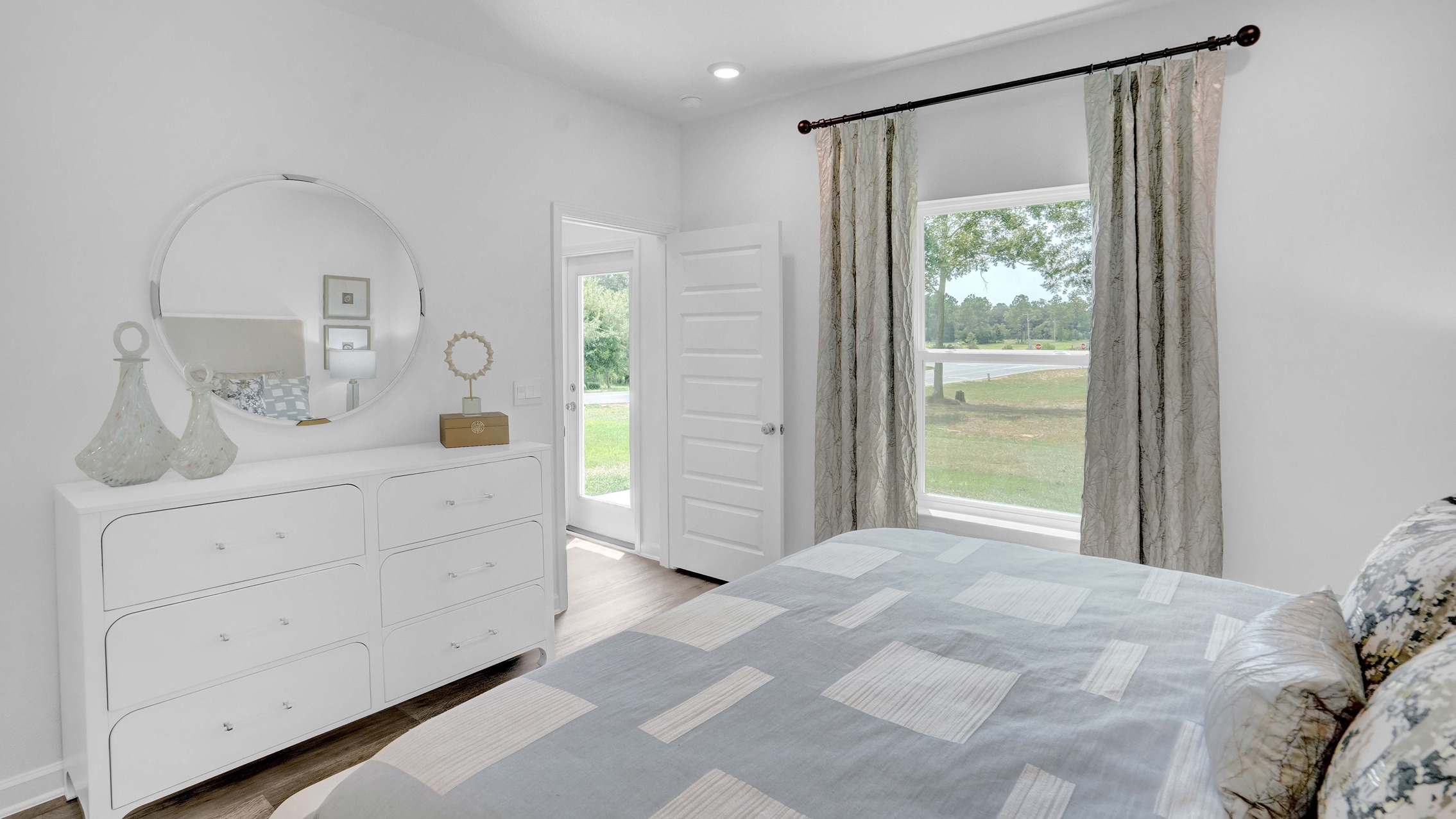 The primary bedroom has curtains and windows and is facing the wall.