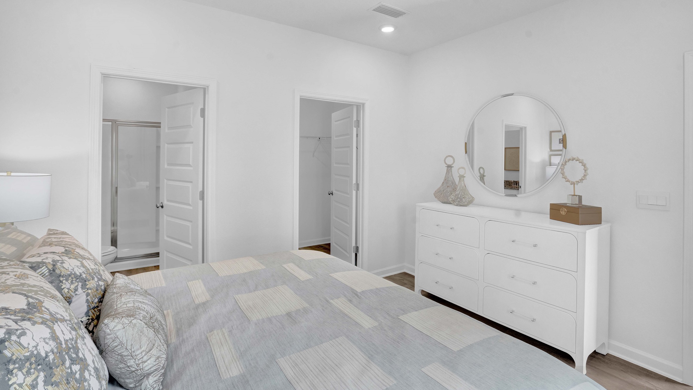 The bed faces the dresser against the wall.