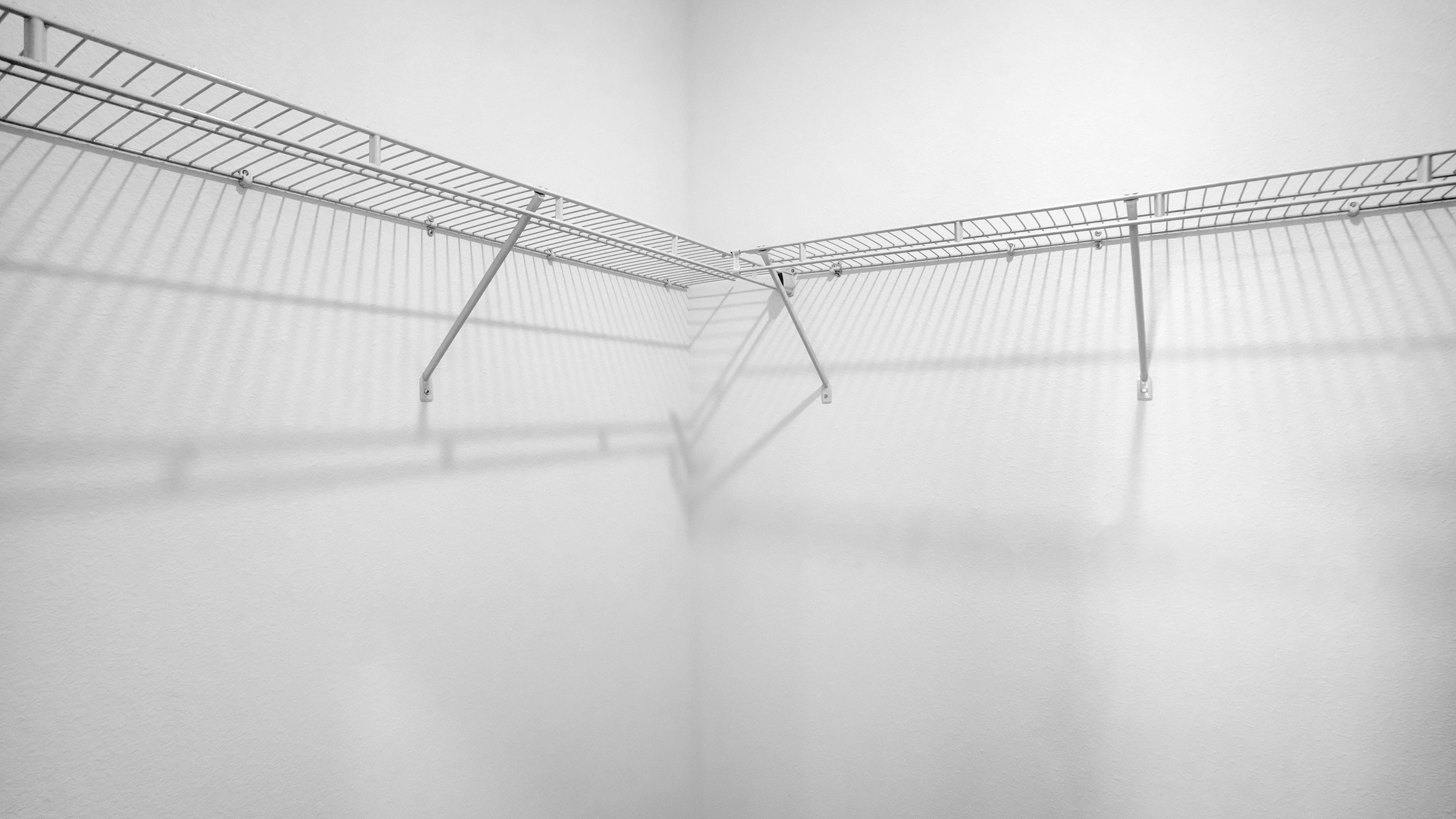 The closet has white walls and wire shelving.