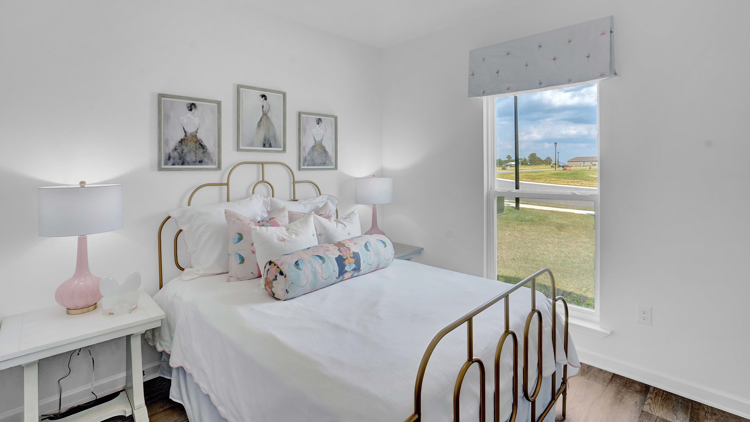 Bedroom set with lamp on next to the windows.