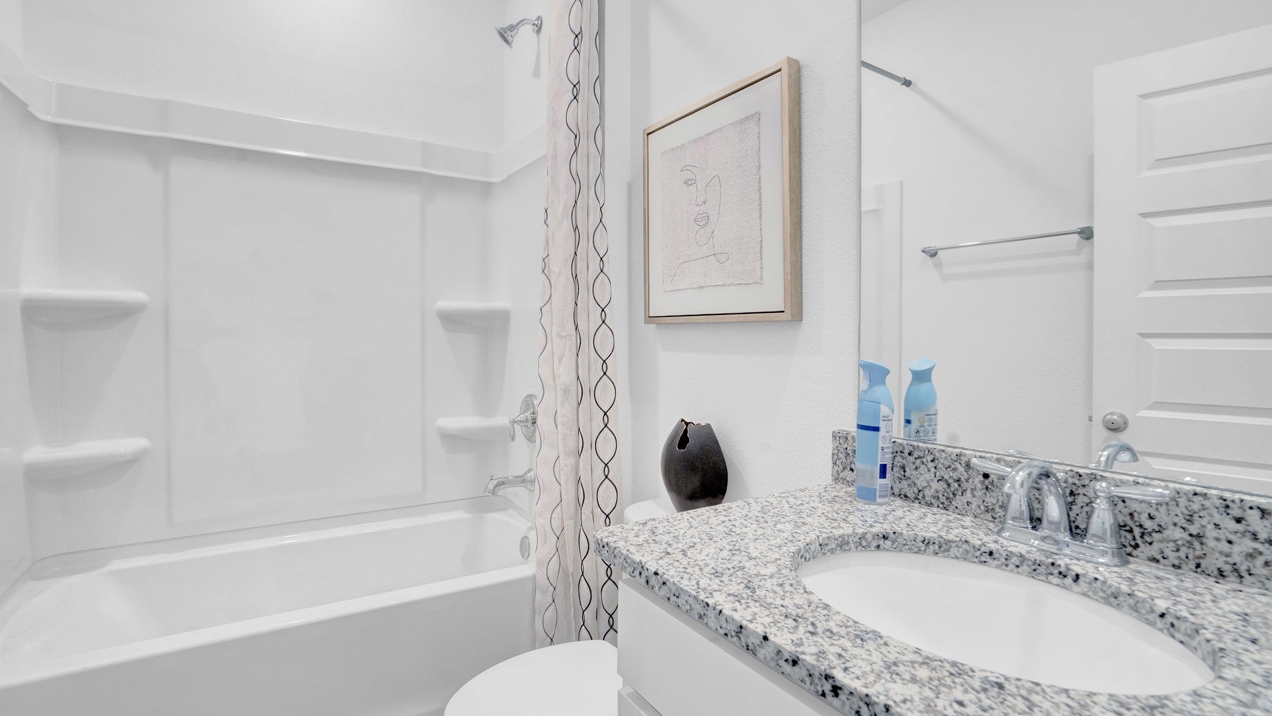 The bathroom has a standup tub and shower comb with a sink and toilet.