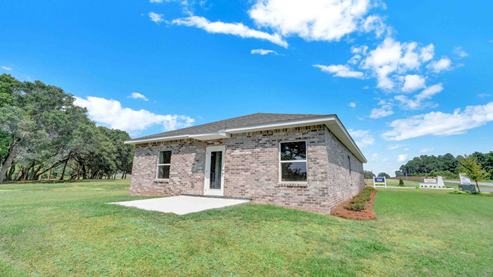 Exterior of home under blue sky and green grass.