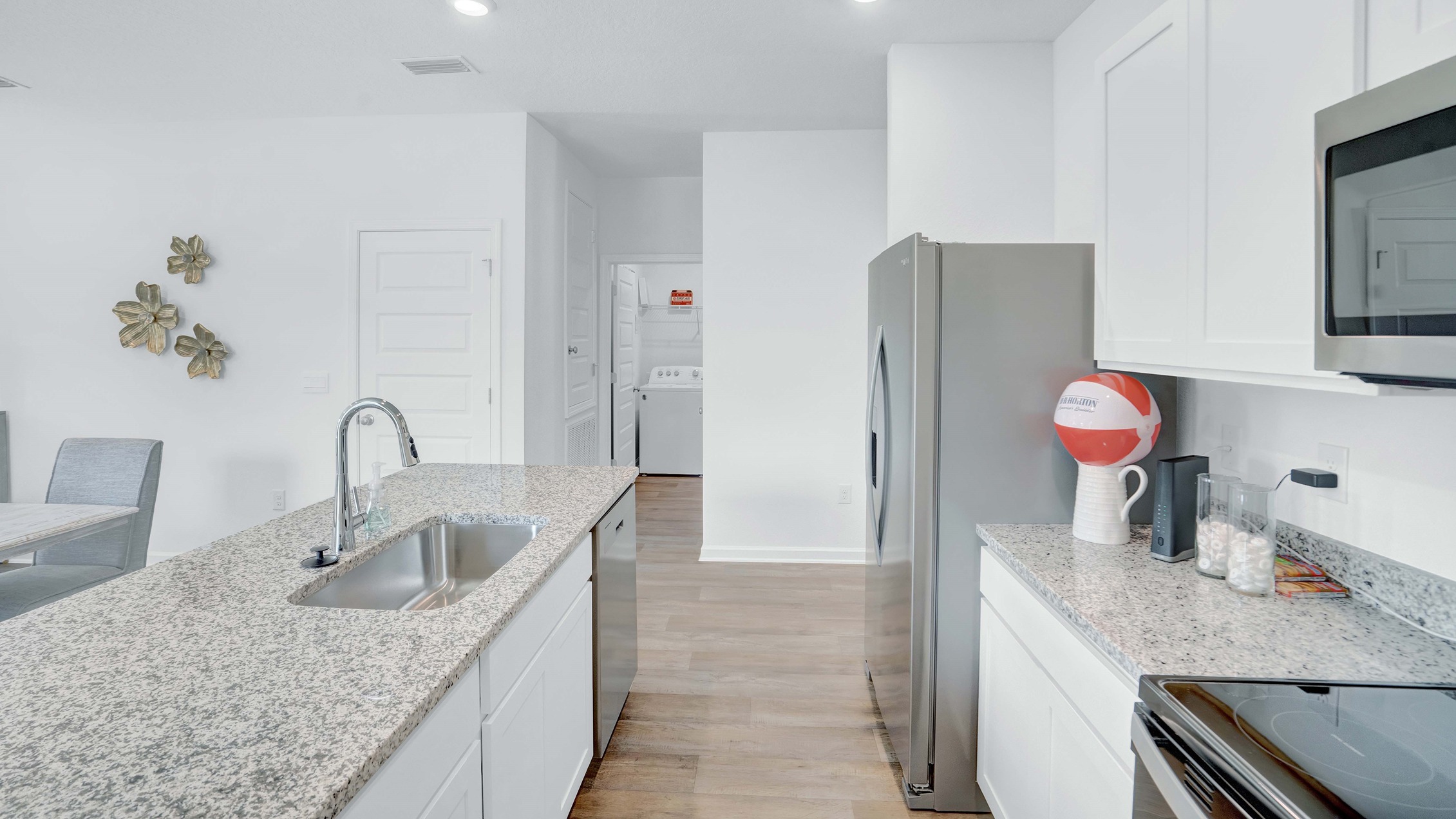 Kitchen with island, granite countertops, appliances and cabinets from a side angle.