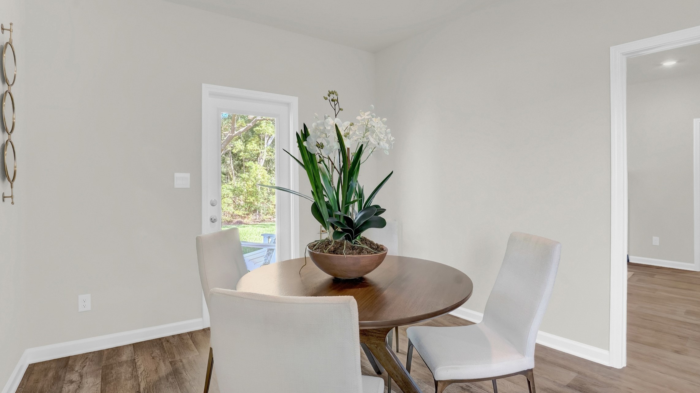 The breakfast area shows a round table, chairs and openings to other areas of the home.