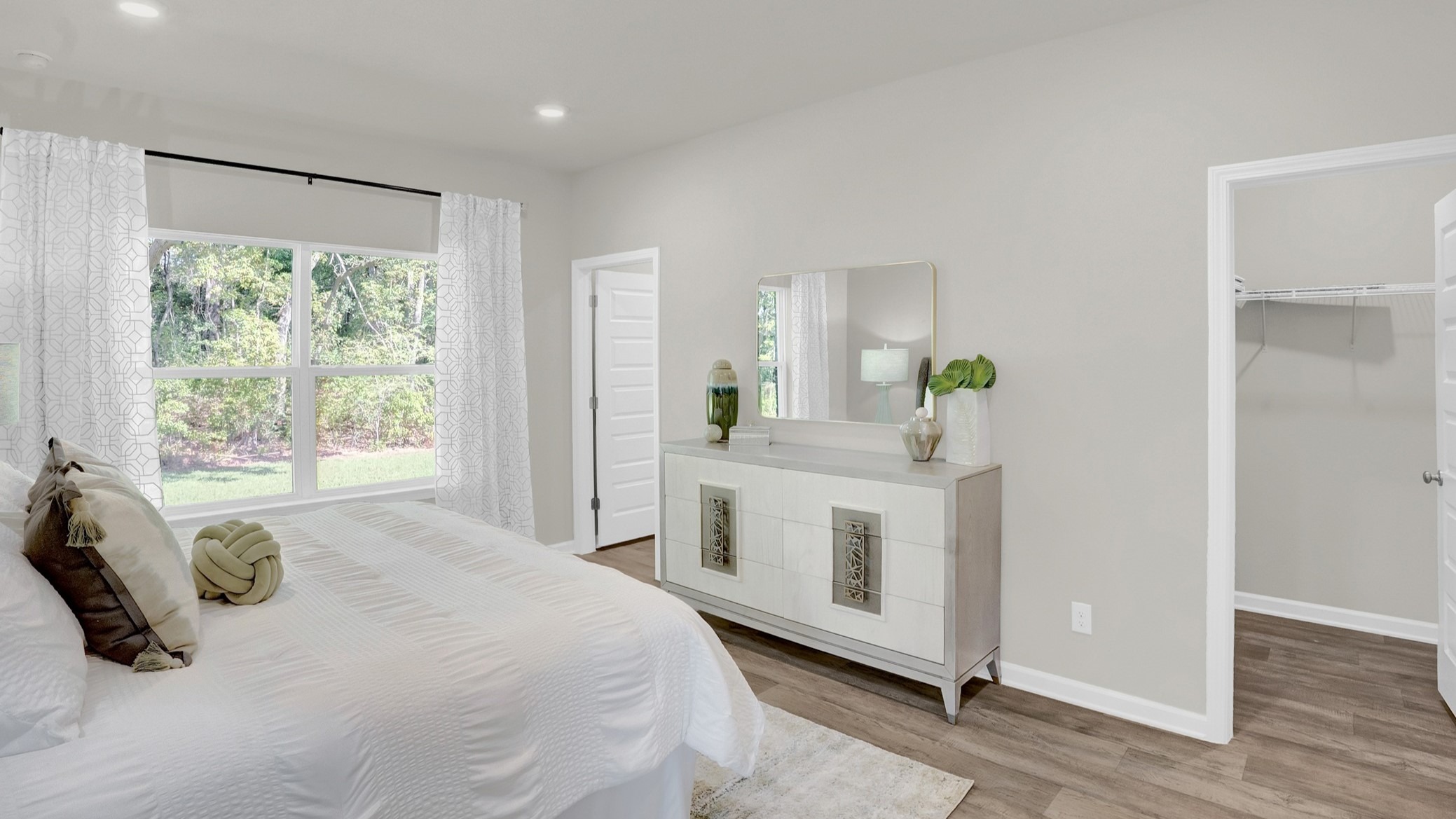 Bedroom with recessed lighting and large windows.