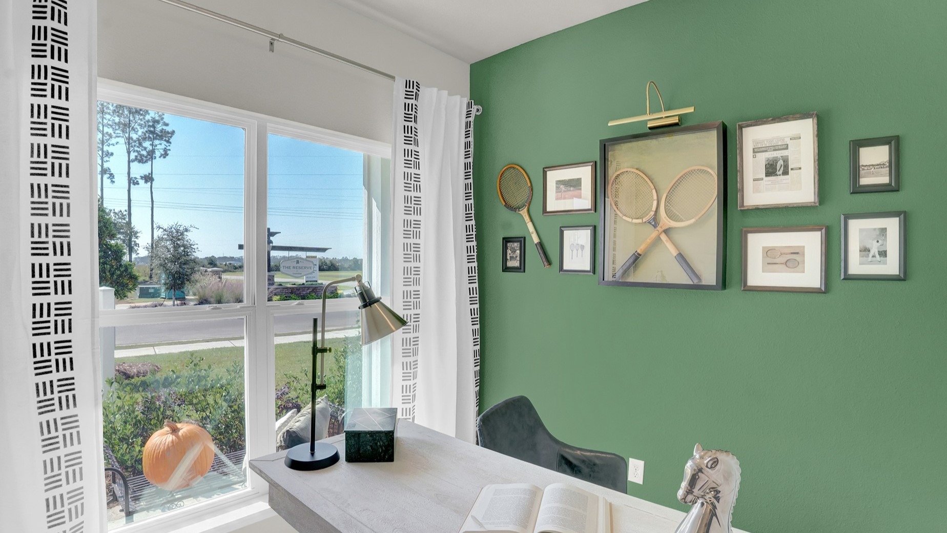 Office area and study with green walls and desk.