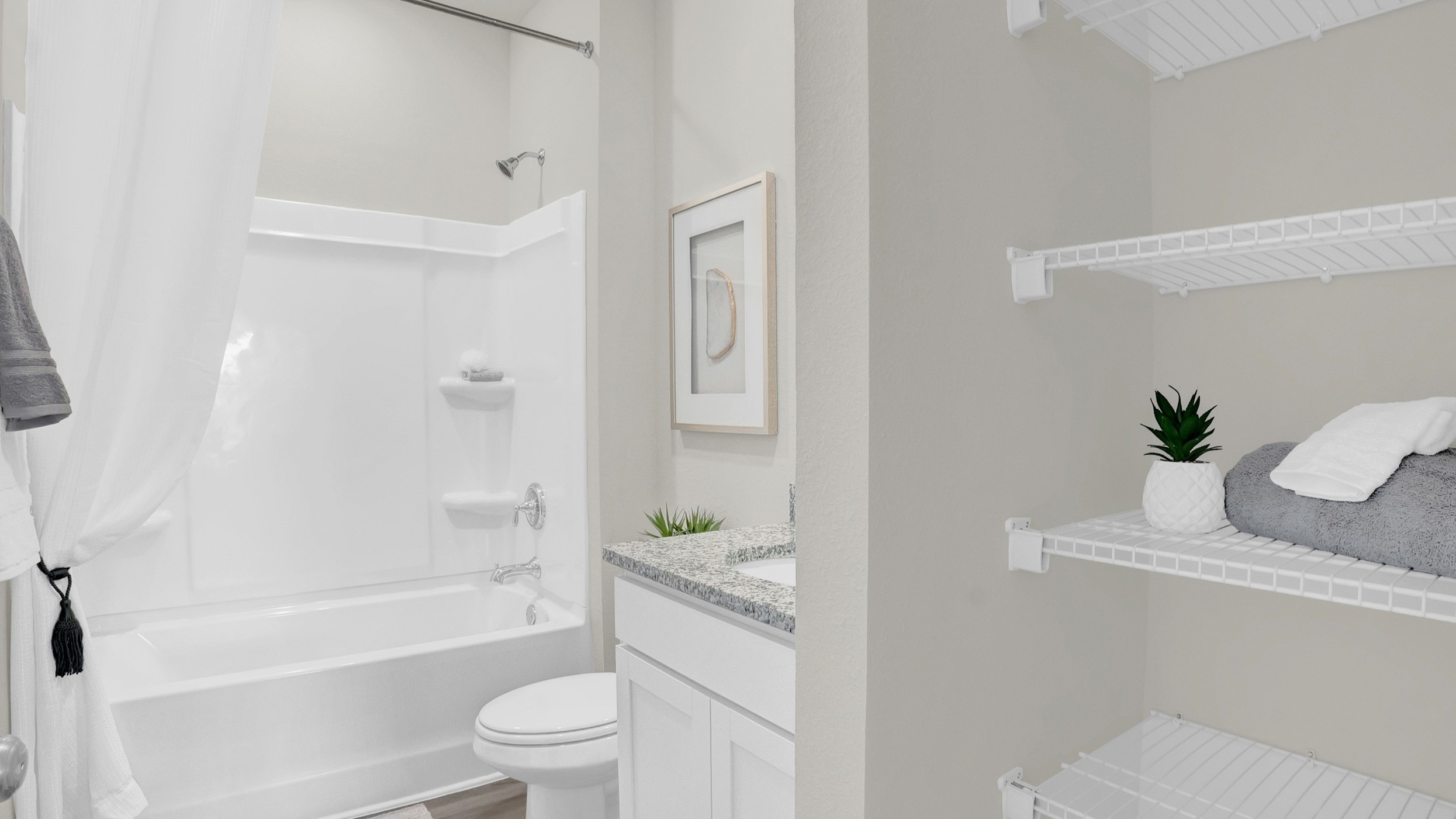 Secondary bathroom with tub and shower combination and closet with shelving.