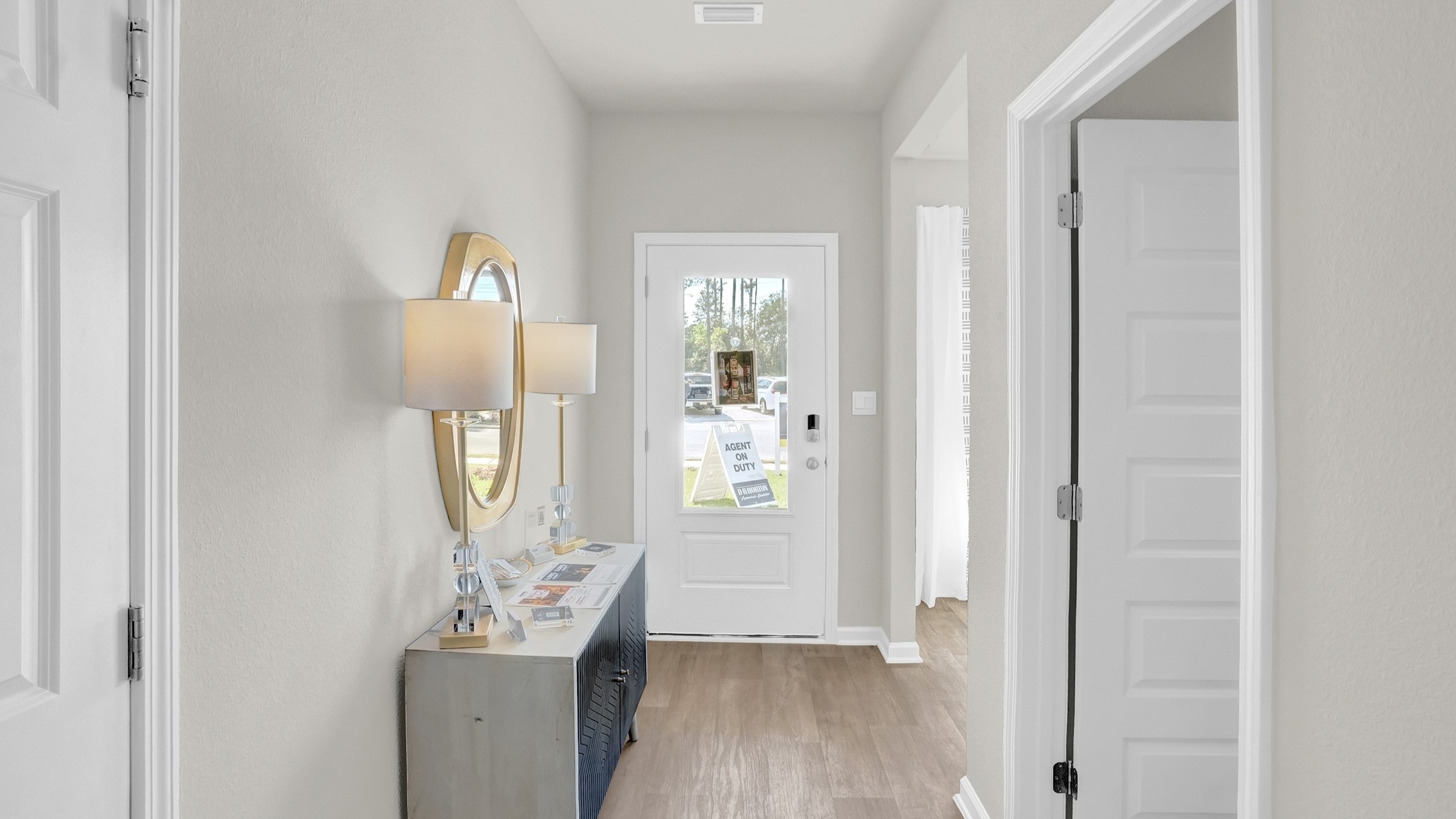 Foyer with door with windows, natural light and furniture.
