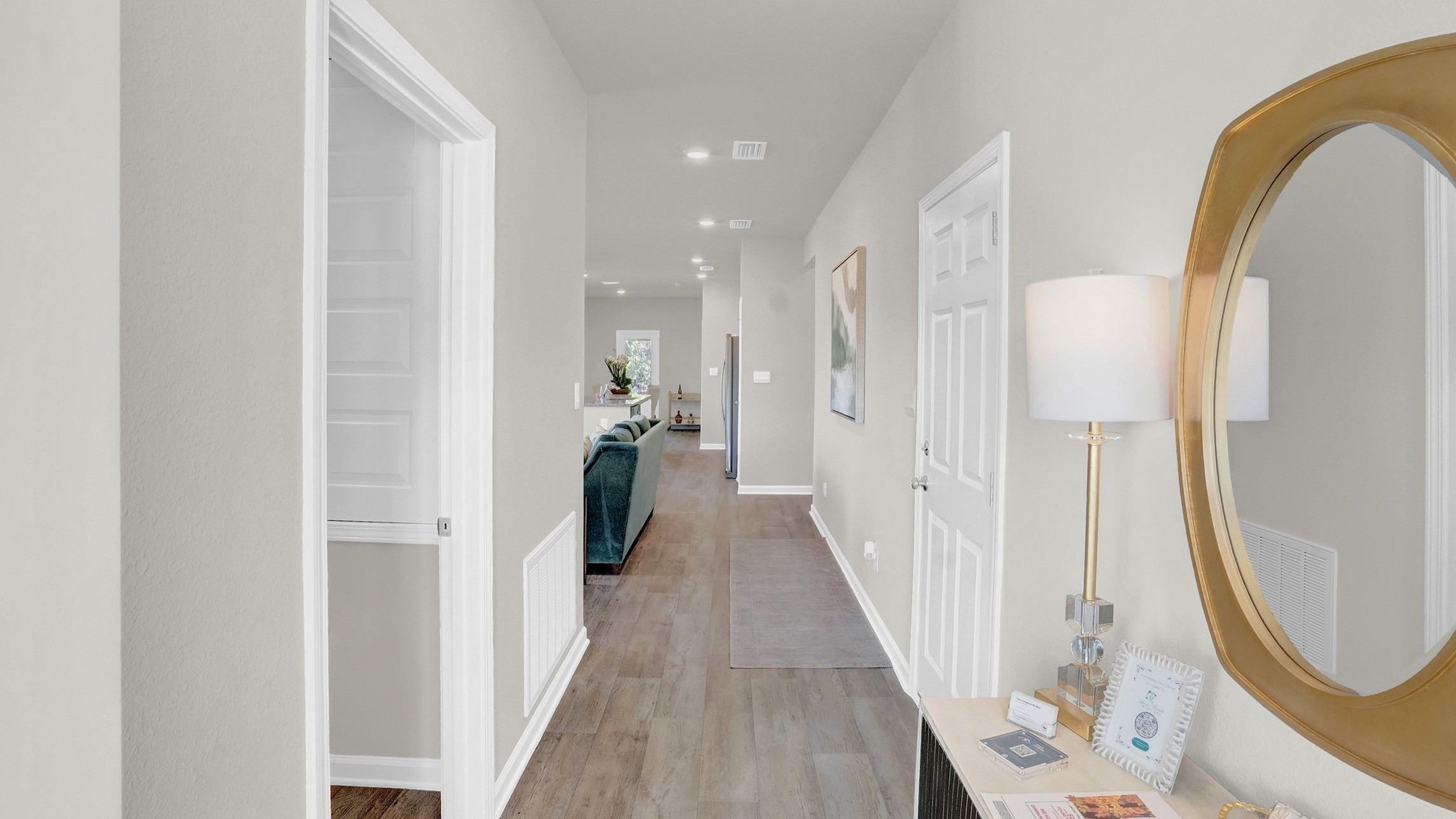 Hallway with lights, mirrors and hardwood floors.