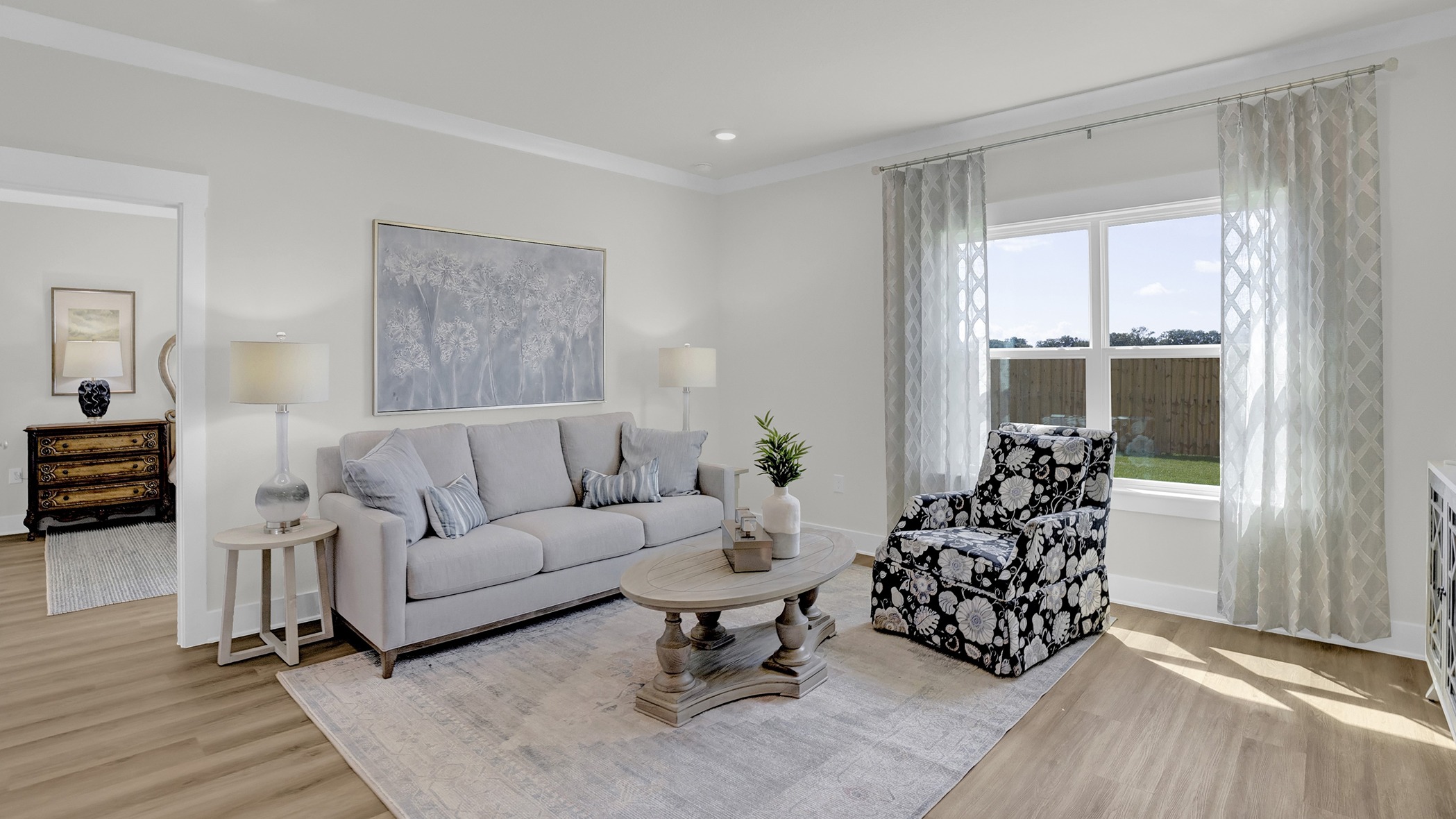 Open-concept living room with large windows, illuminated by natural light.