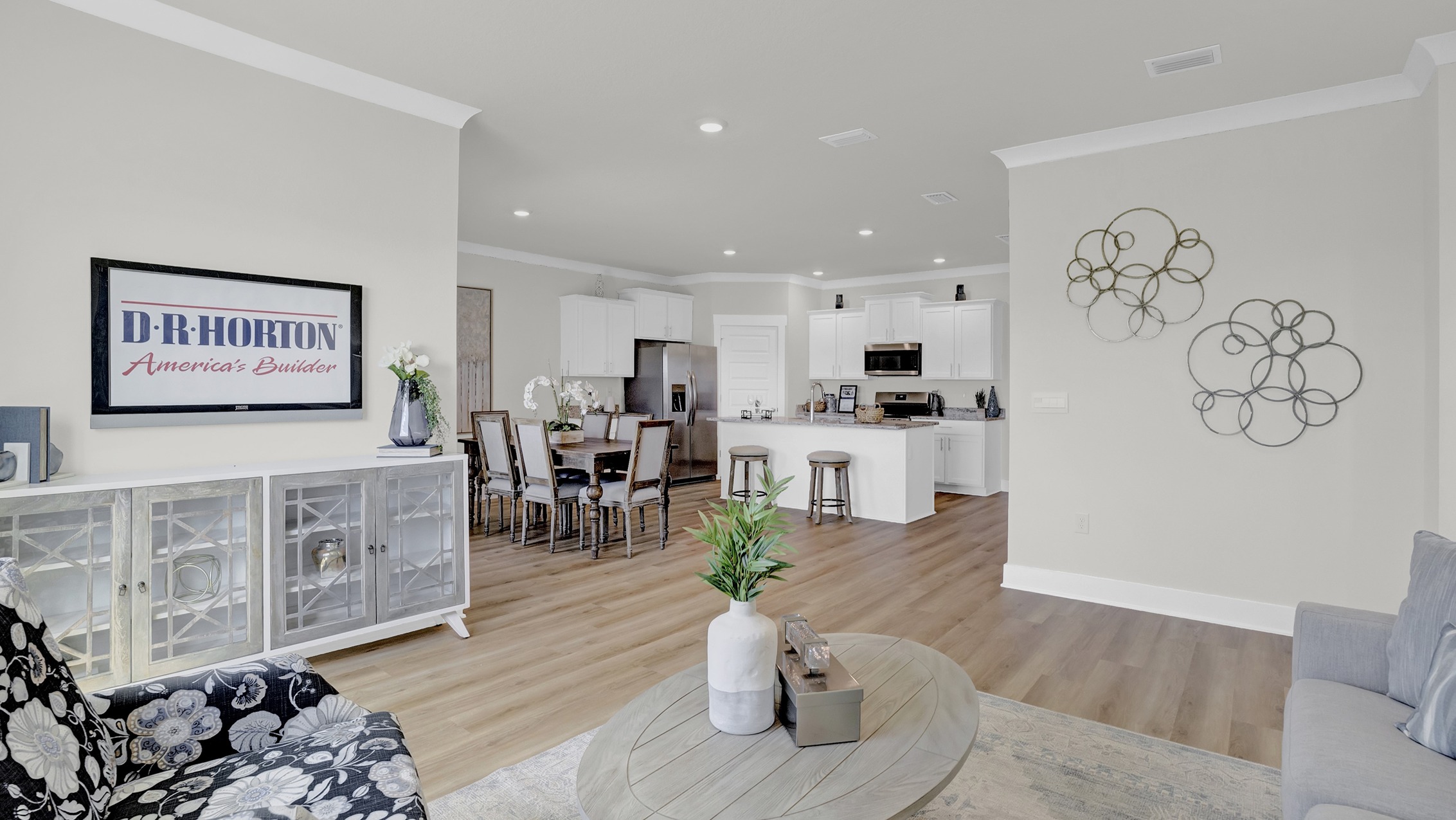 Open-concept living room with large windows, illuminated by natural light.