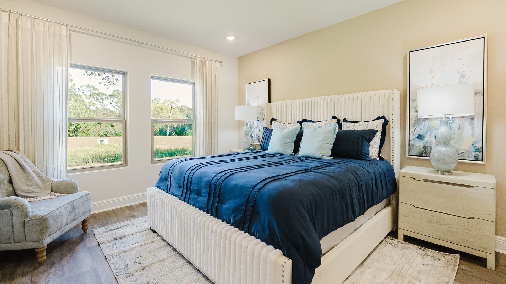 Open concept primary bedroom room with 9-foot ceilings and large windows.
