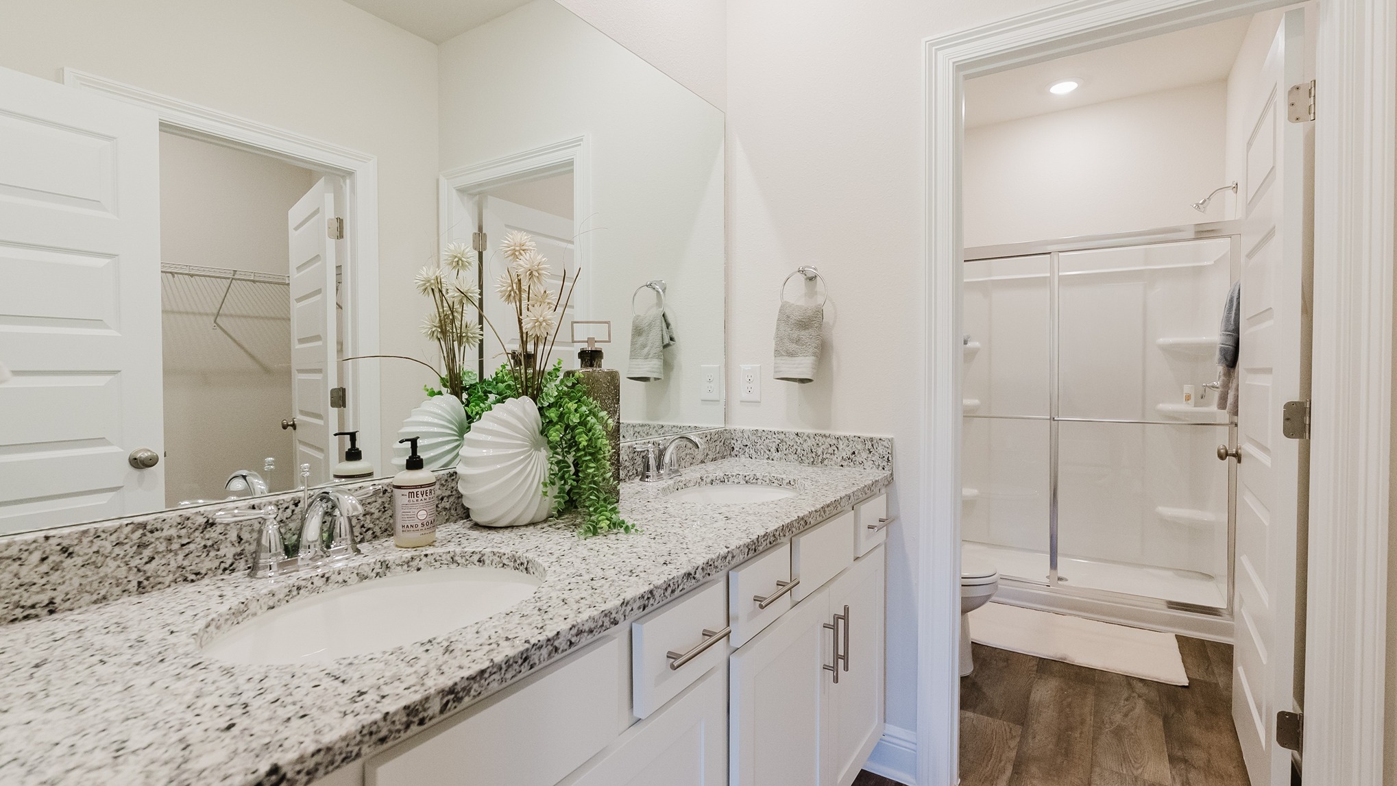Primary bathroom with dual sink vanities and granite countertops.