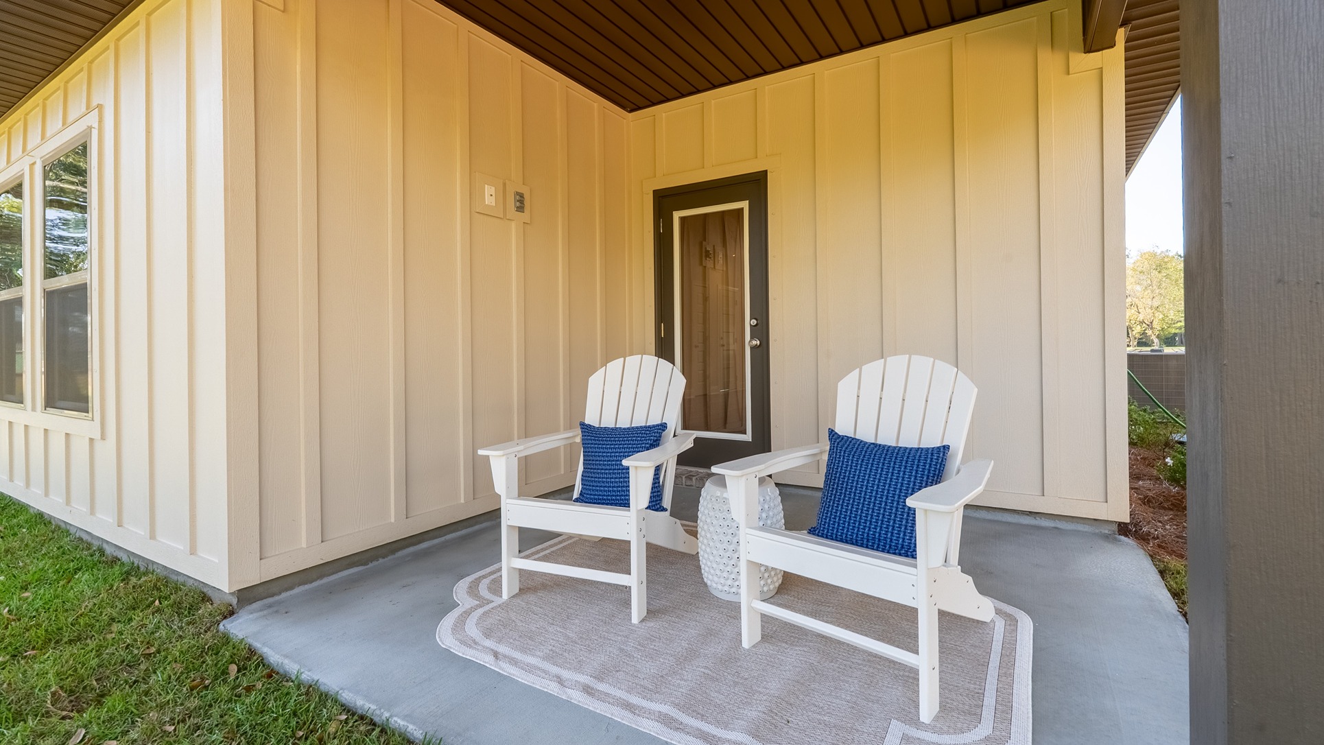 Covered rear patio overlooking pond in backyard.