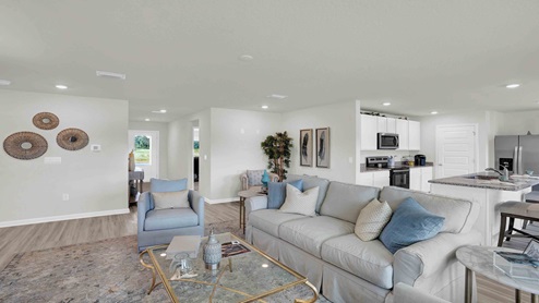 Open concept living room with light walls and wood floors.