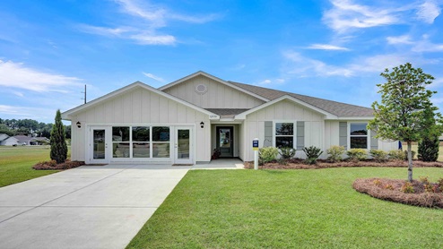 Brand new home with light Hardie board siding and light gray shutters with 3 gables and beautiful yard.