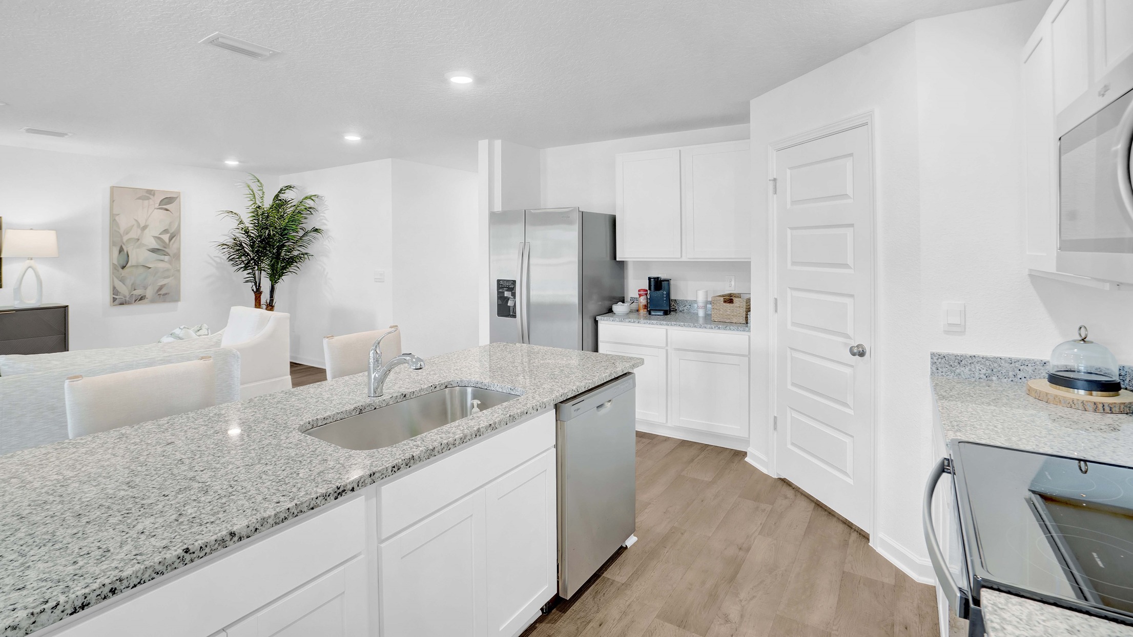 Large Ryder kitchen with shaker-style cabinetry, a corner pantry, and large central island overlooking living room.