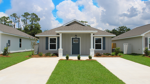 One-story home with board and batten exterior and a covered front porch.