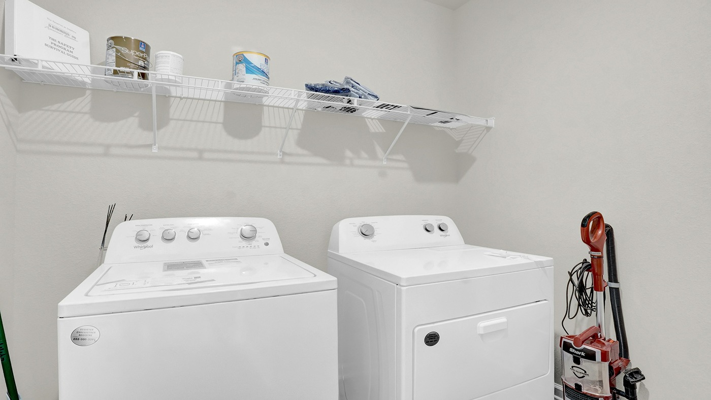 Laundry area is large enough for both washer and dryer and shelving.