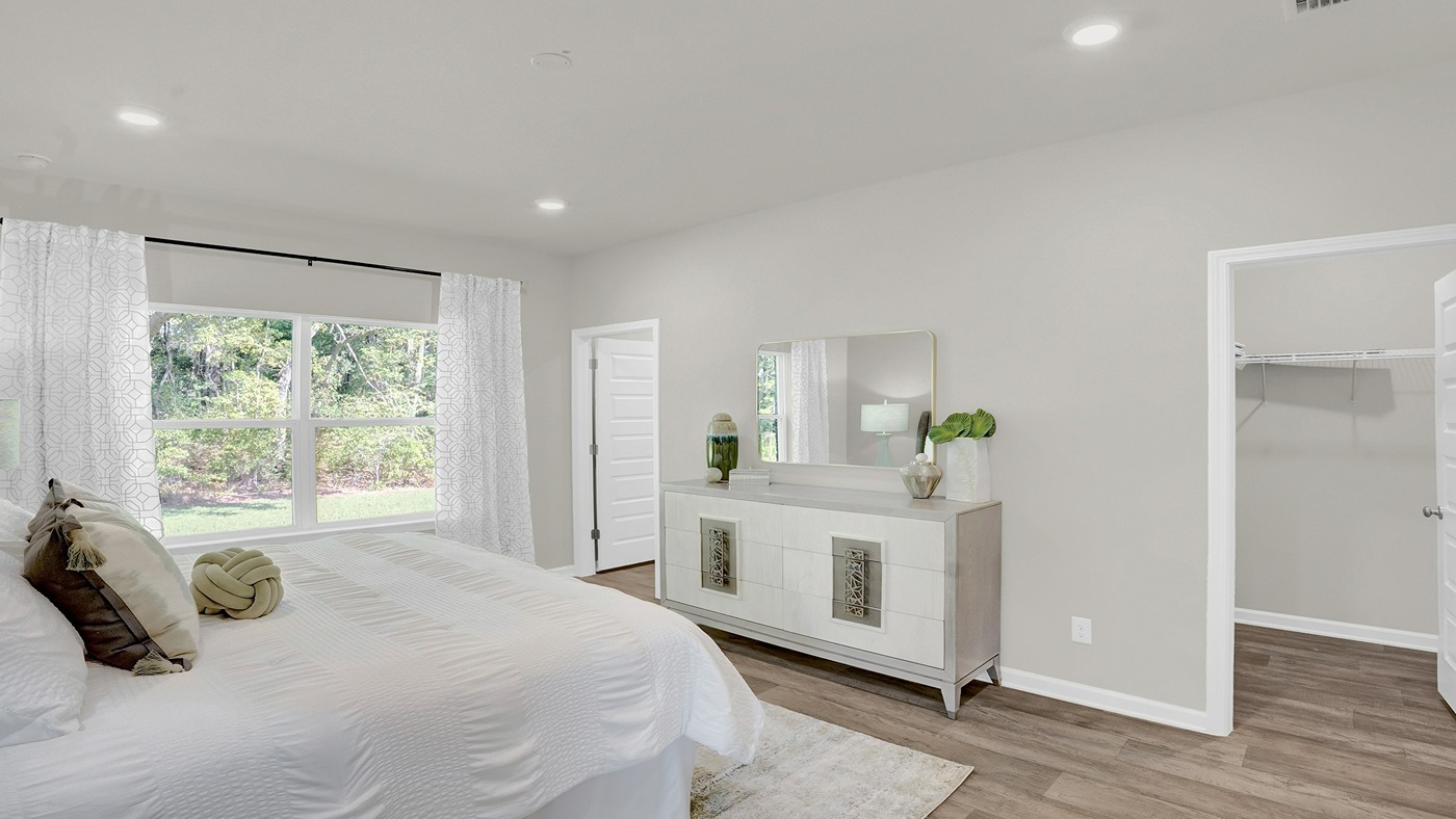 Bedroom with recessed lighting and large windows.