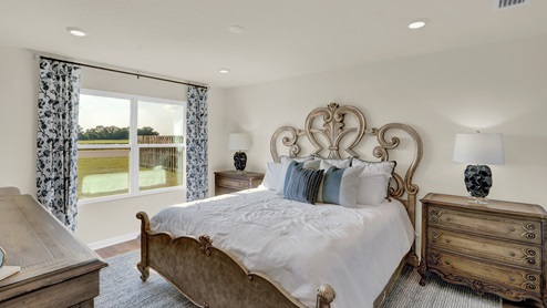 Primary bedroom with abundant natural light from large window overlooking the backyard.
