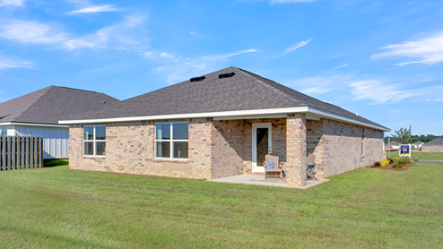 Single-story home with brick siding, a covered back porch, and spacious backyard.