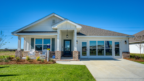 Single-story home with white board and batten, a brick water table, and two-car garage.