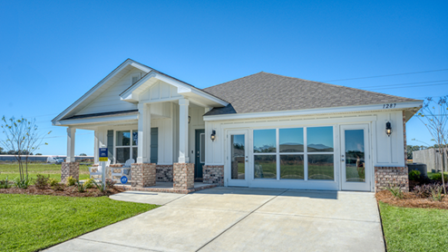 Single-story home with white board and batten, a brick water table, and two-car garage.