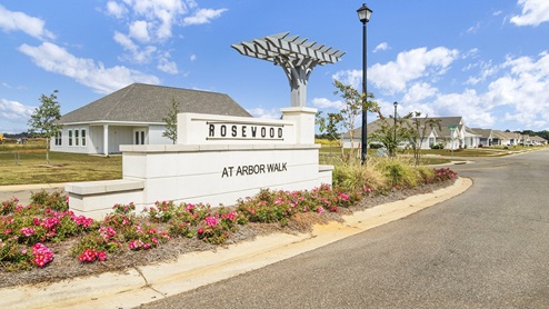 Beautifully landscaped entrance monument surrounded by vibrant roses.