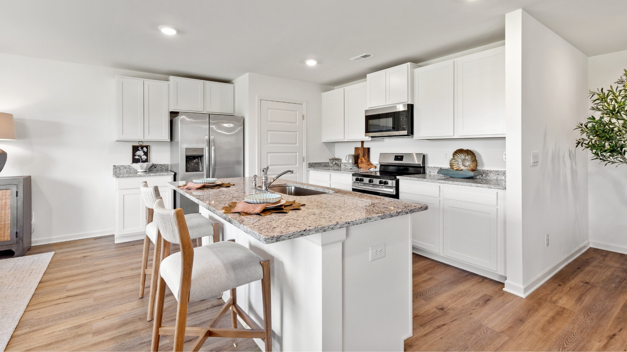 Spacious kitchen with shaker-style cabinetry, granite countertops, a central island, and stainless steel appliances.