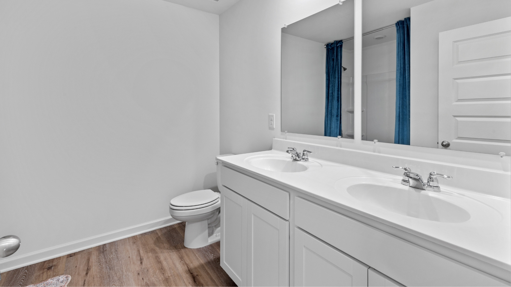 Spare bathroom with dual sink vanities located towards the front of the home.
