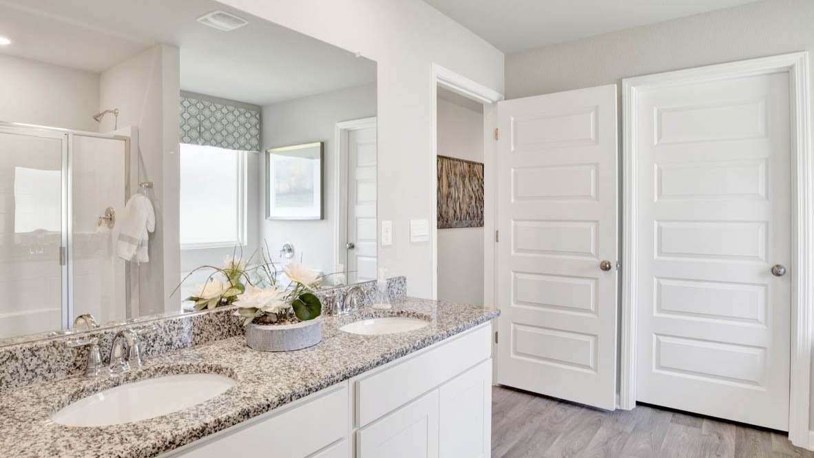 Primary bathroom with dual sink vanities and granite countertops.