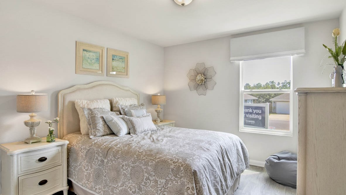 Spare bedroom with light-colored carpet.