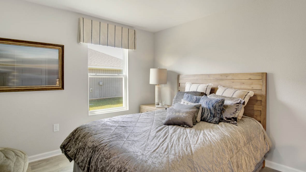 Spare bedroom with light-colored carpet.