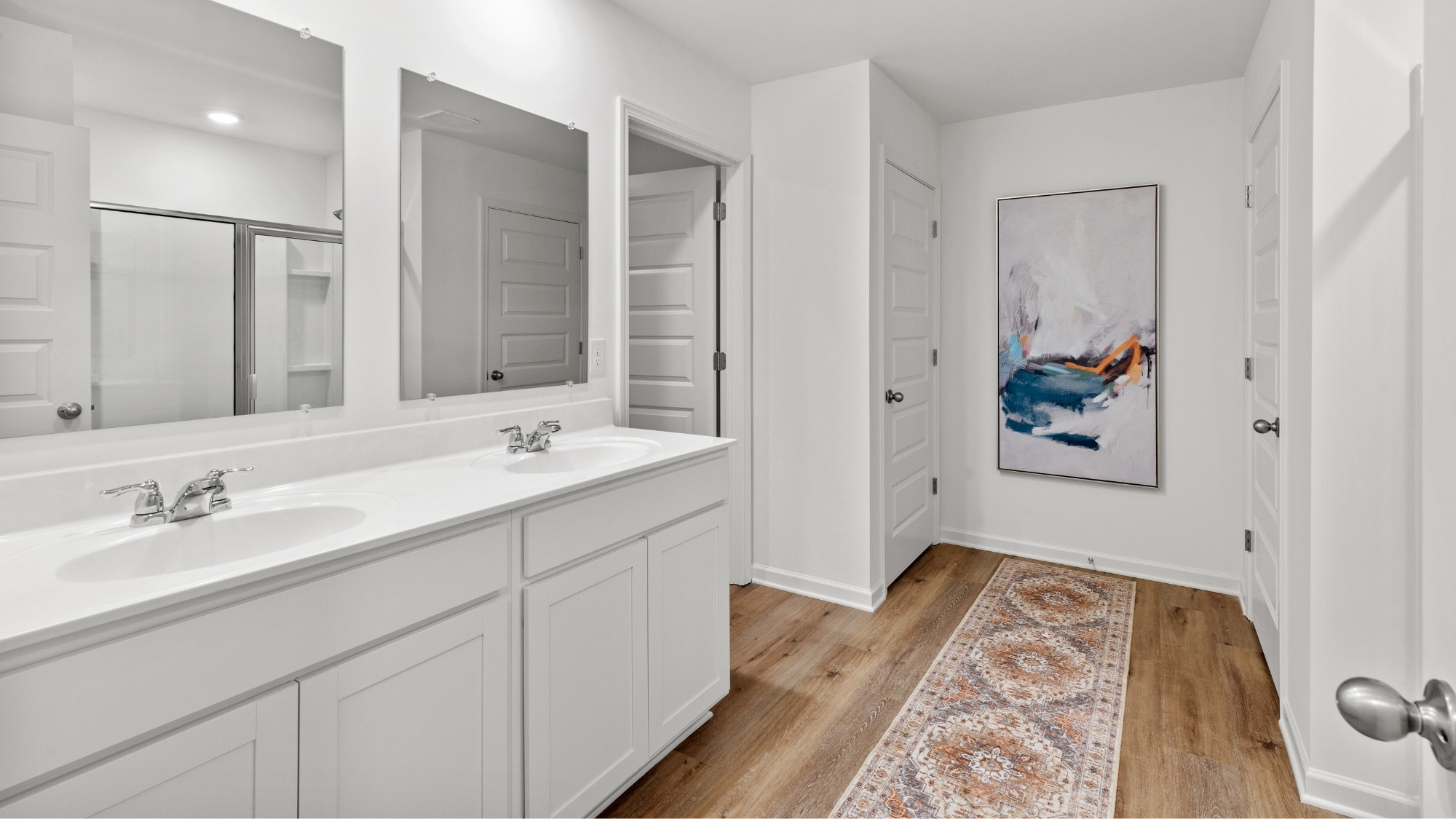 Primary bathroom with dual sink vanities.