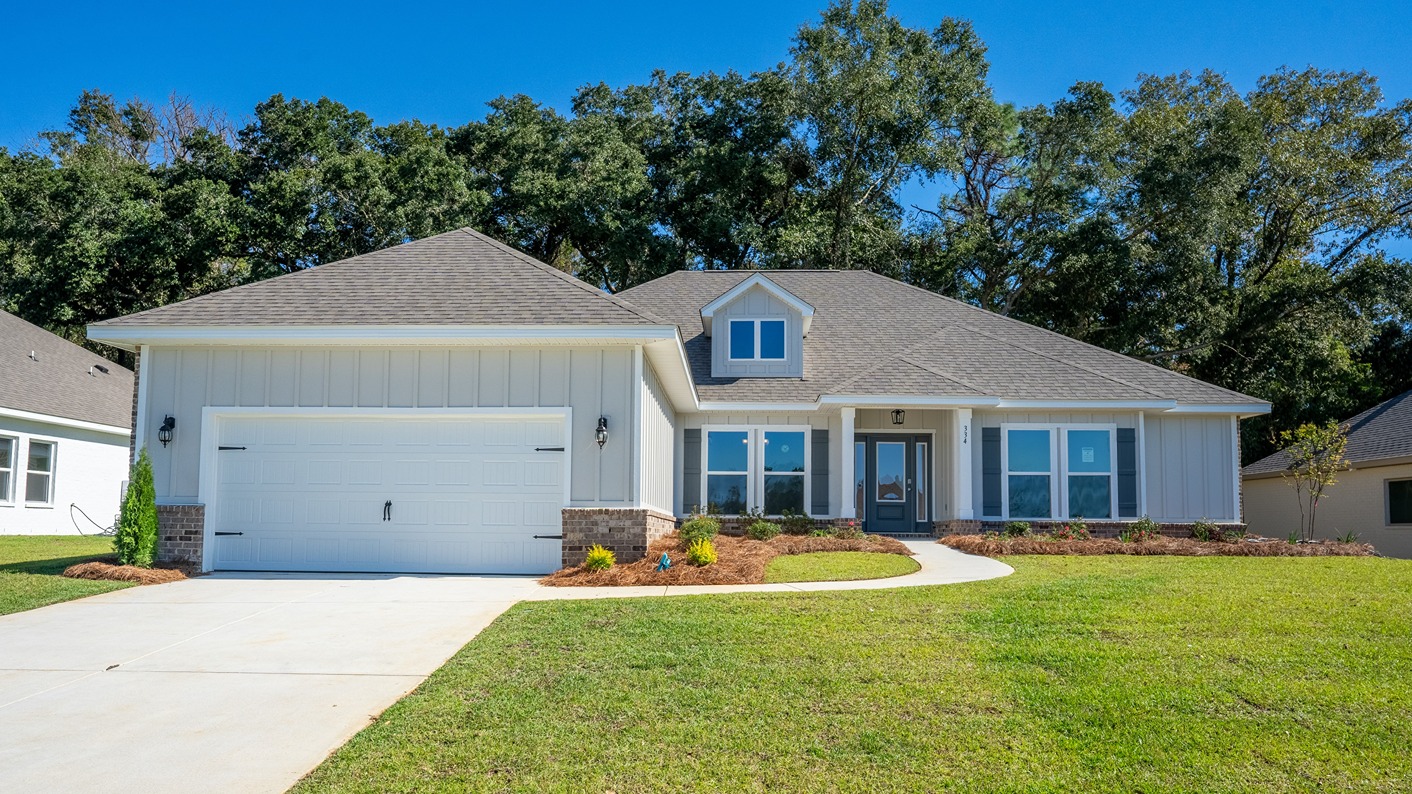 One-story new home with board and batten exterior, a brick water table, and two-car garage.