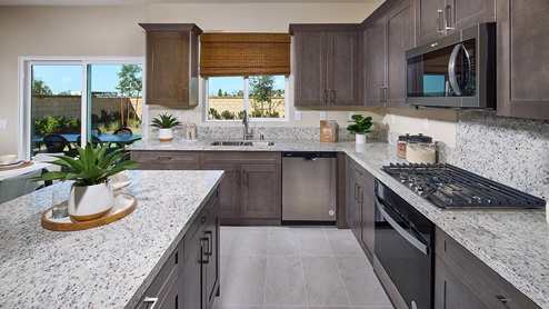 Open-concept kitchen area with dark cabinets and granite countertops