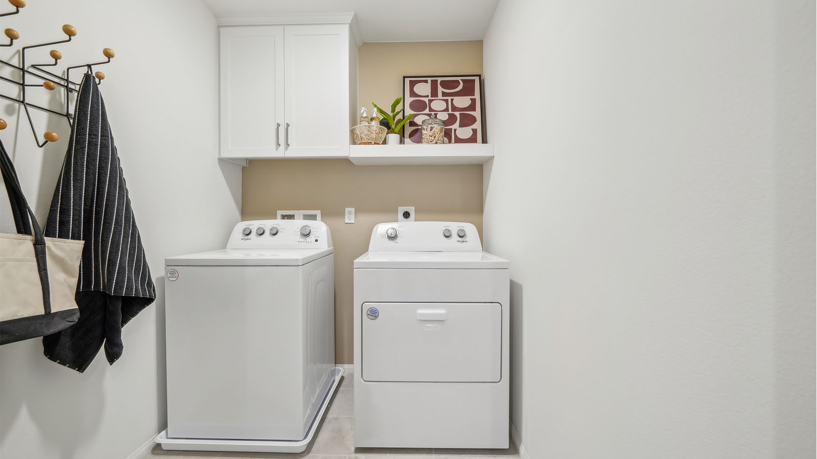 Laundry room with washer, dryer, and upper white cabinet and shelve