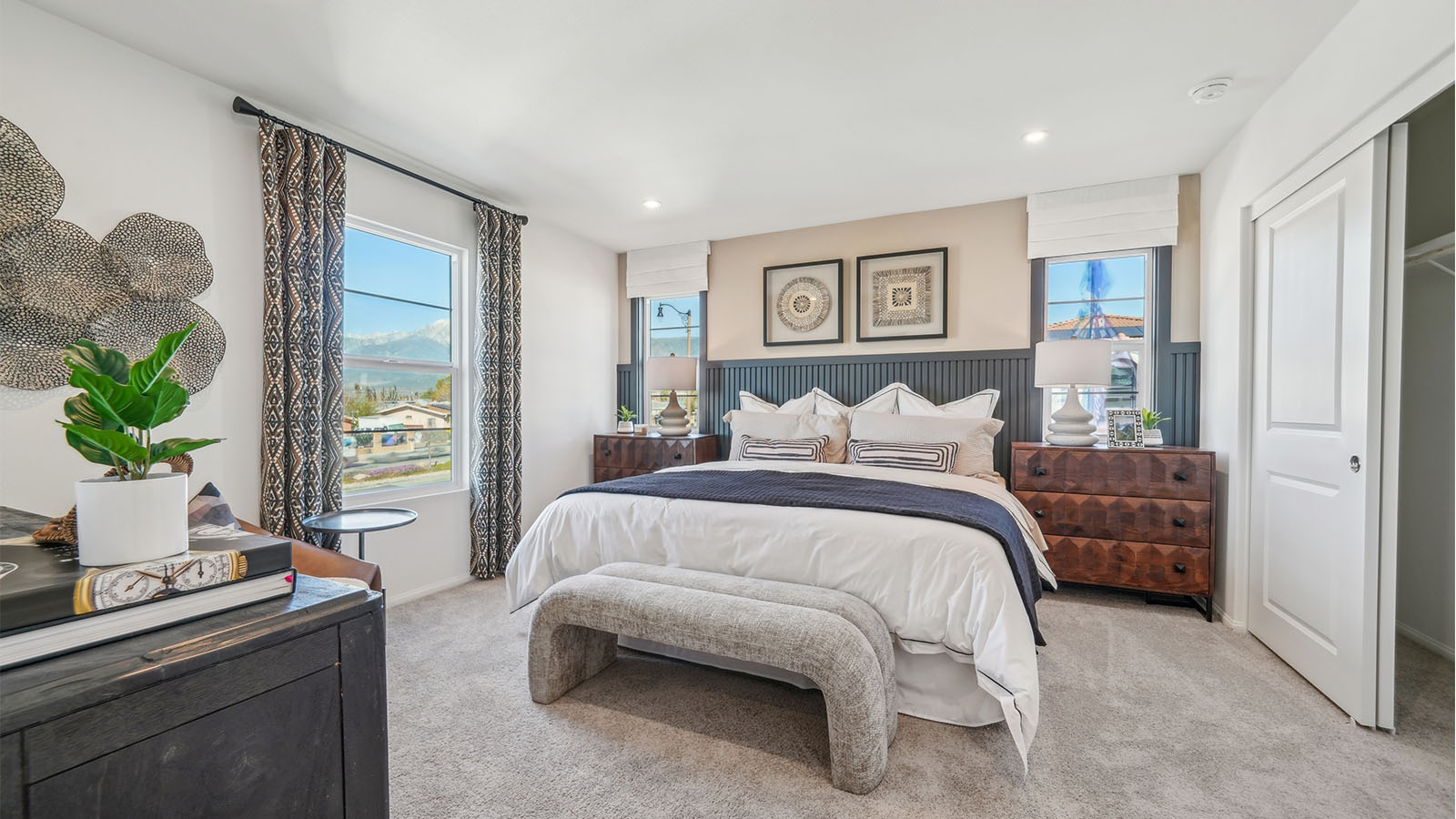 Primary bedroom with king bed, accent wall, and plush carpet