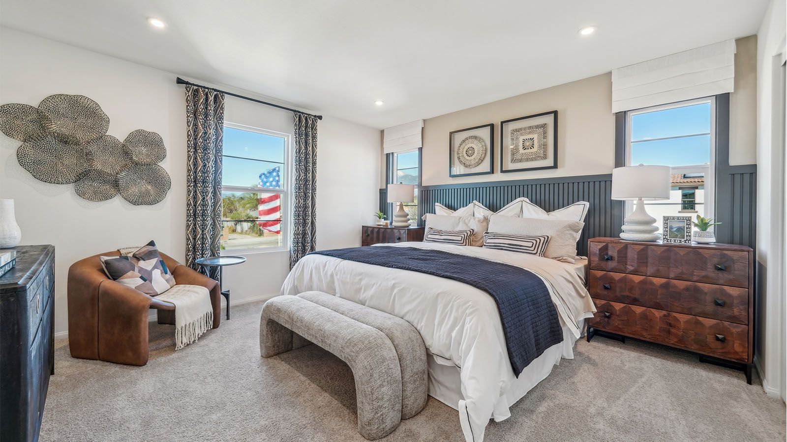 Primary bedroom with king bed, accent wall, and plush carpet
