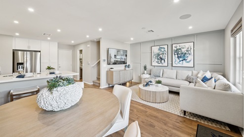 Modern open-concept kitchen with white cabinets and stainless steel applia