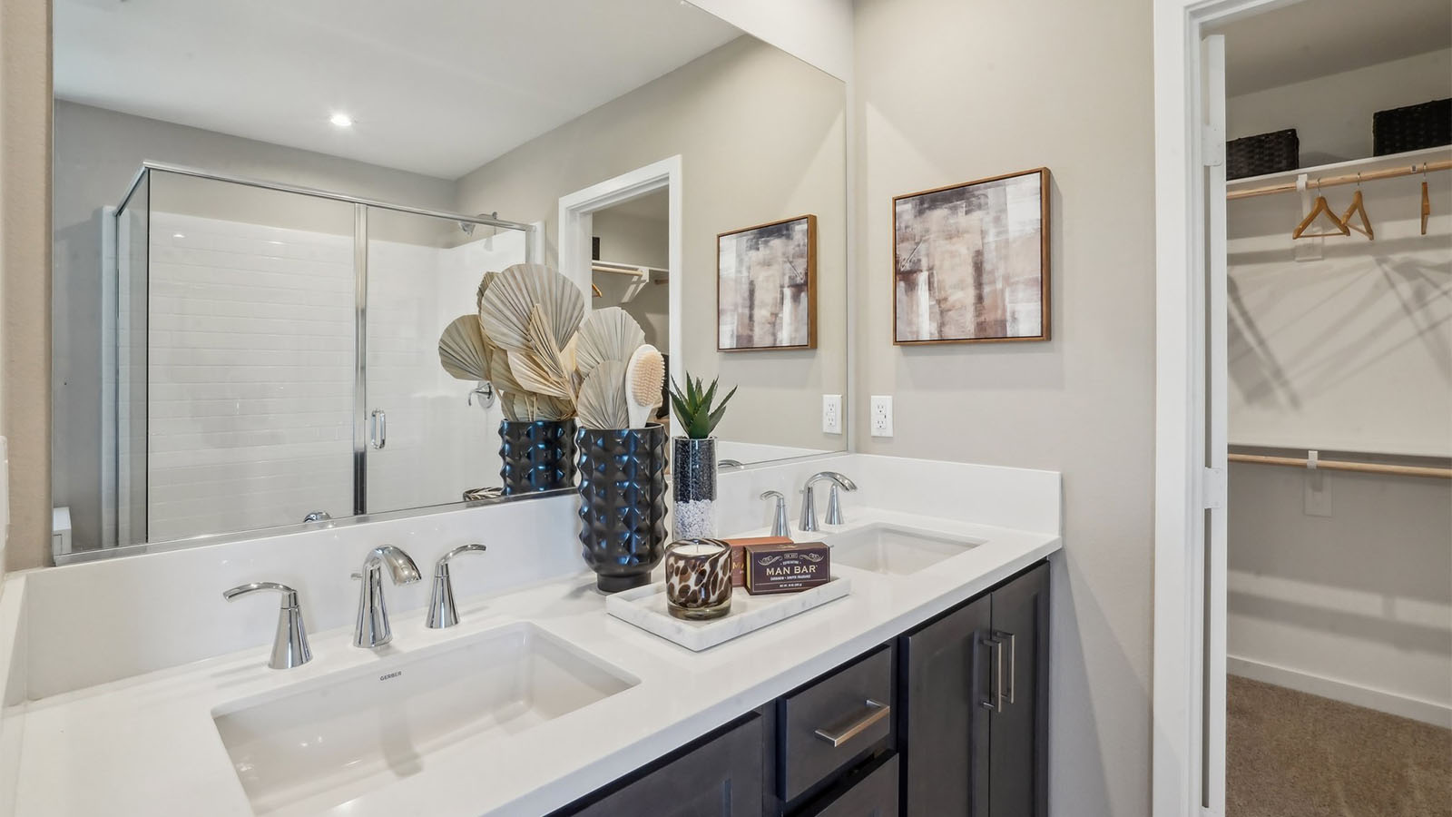 Primary bathroom with dual sinks and shower and walk-in closet
