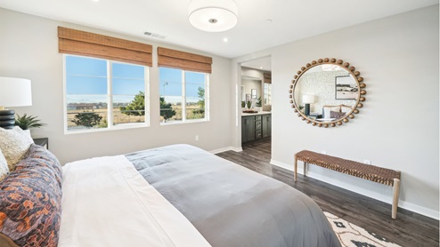 Primary bedroom with king bed, accent wall, and laminate flooring