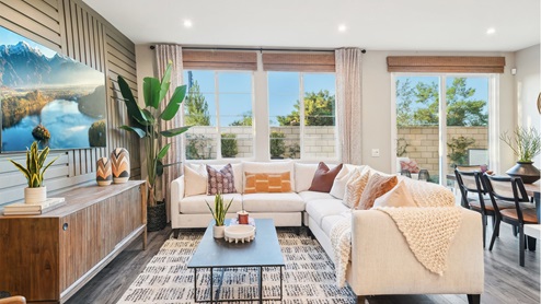 Spacious open-concept great room with accent wall and laminate flooring