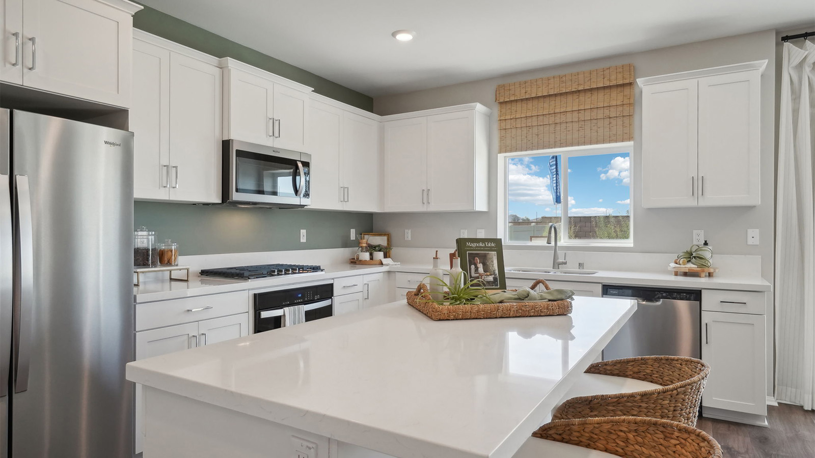 Modern kitchen with white cabinets quartz countertops and stainless steel appliances