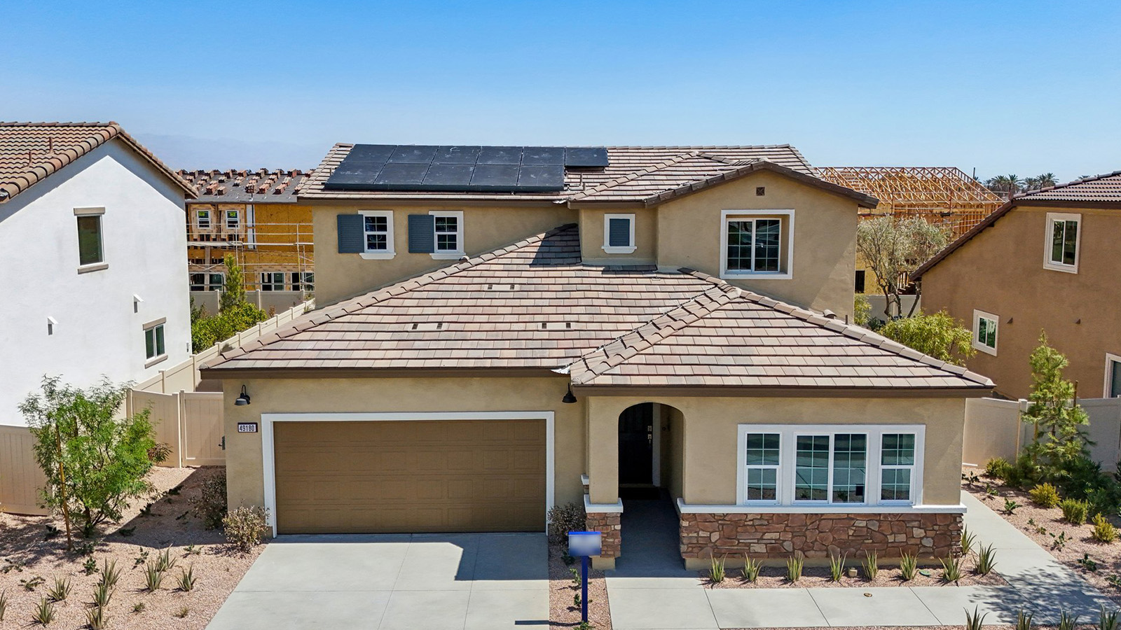 Two-story Tuscan home with stone veneer and two-car garage and shutters