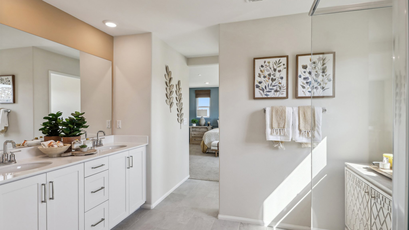 Primary bathroom with dual vanities and shower