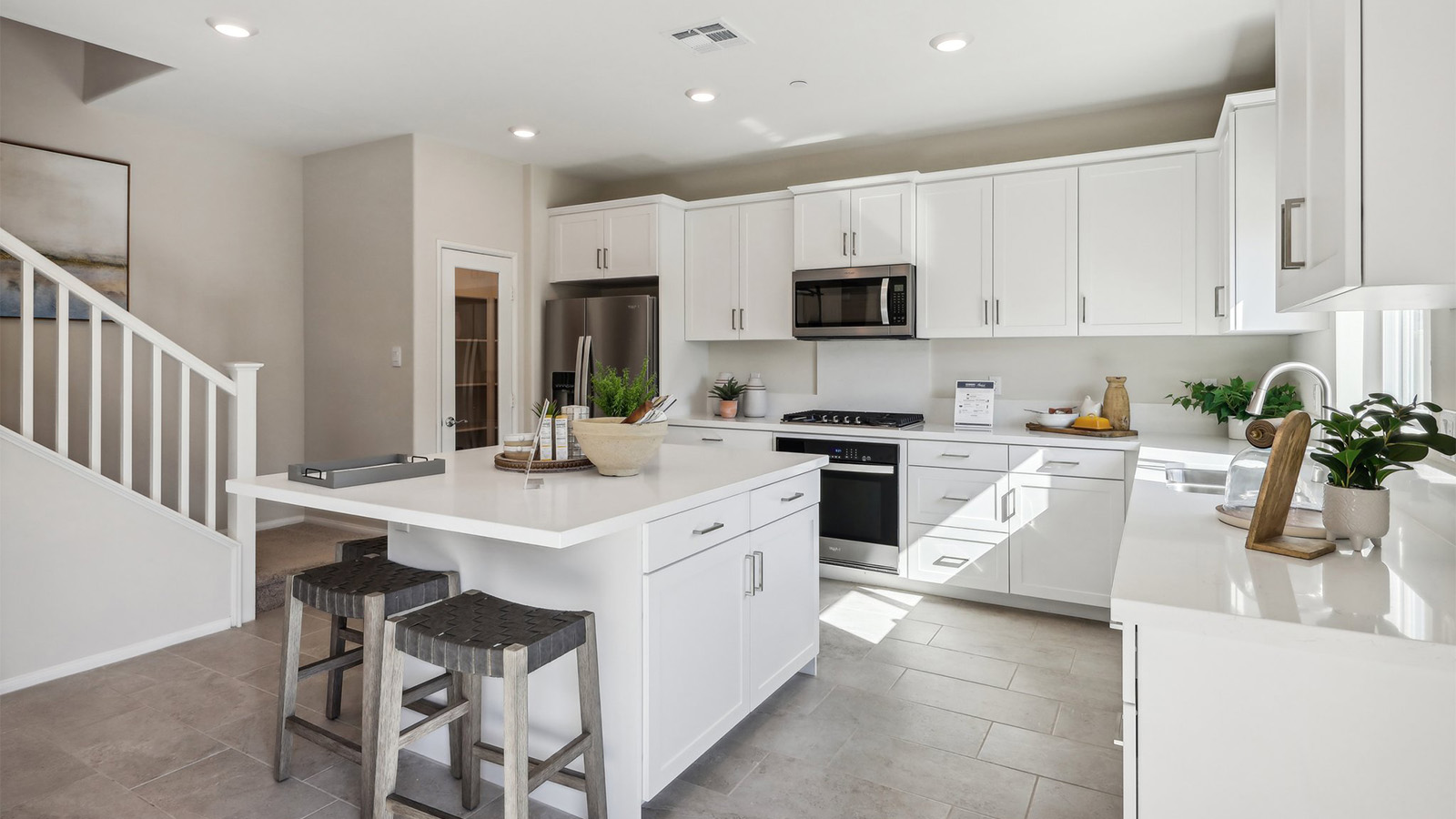 Modern kitchen with white cabinets quartz countertops and stainless steel appliances